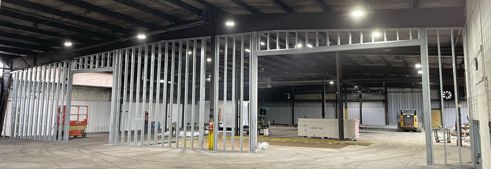 A large warehouse under construction with a lot of metal frames.