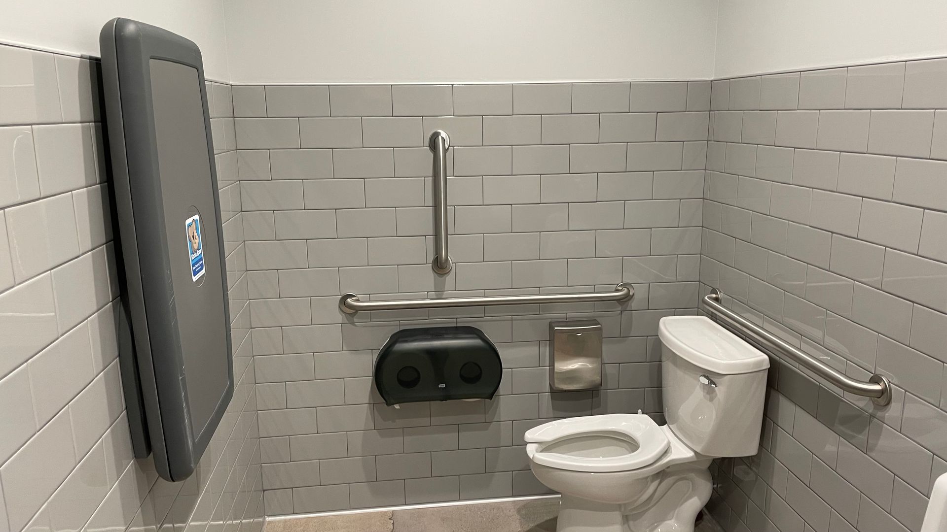 A bathroom with a toilet and a changing table.