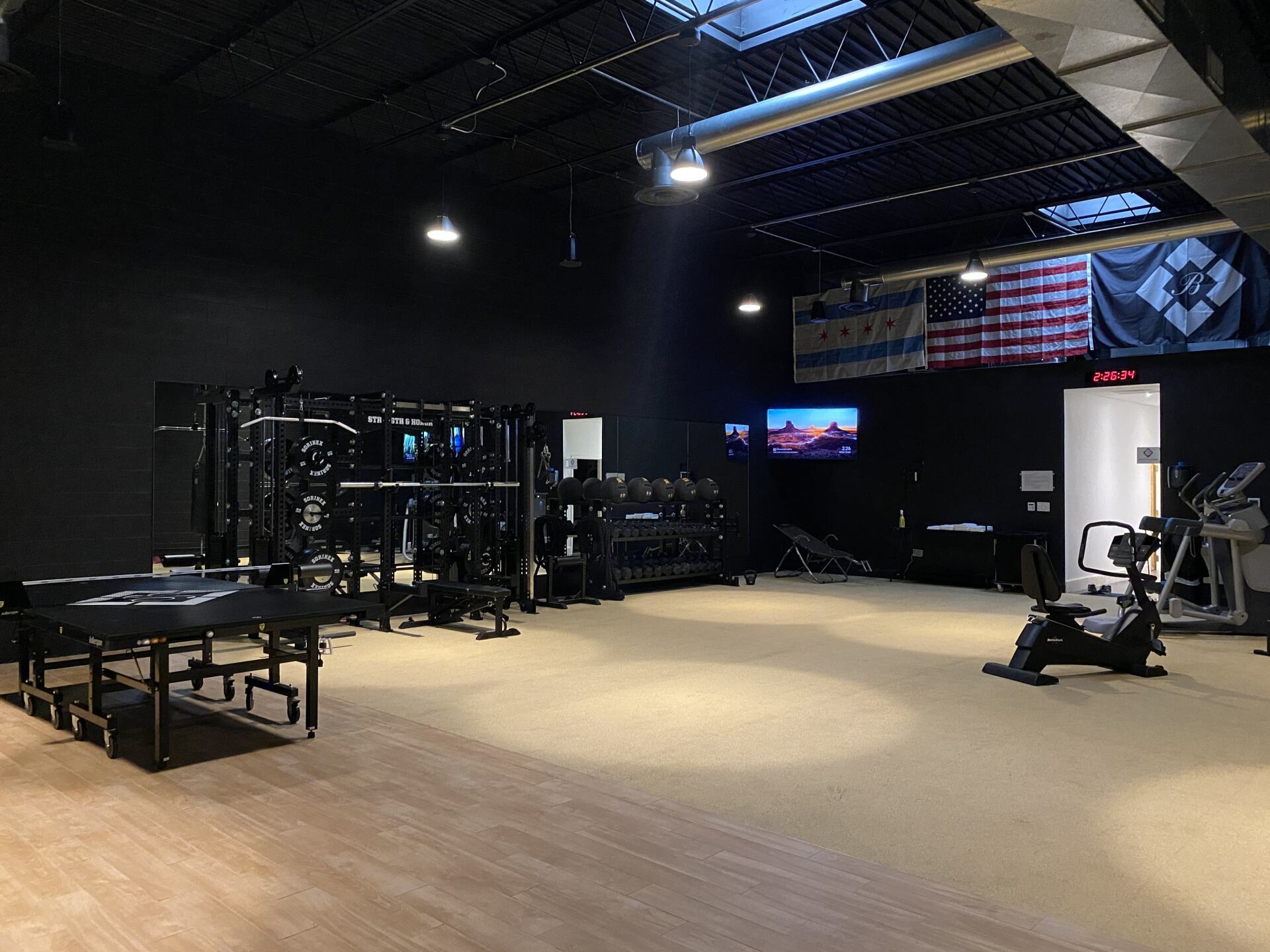 A gym with a ping pong table and a rowing machine
