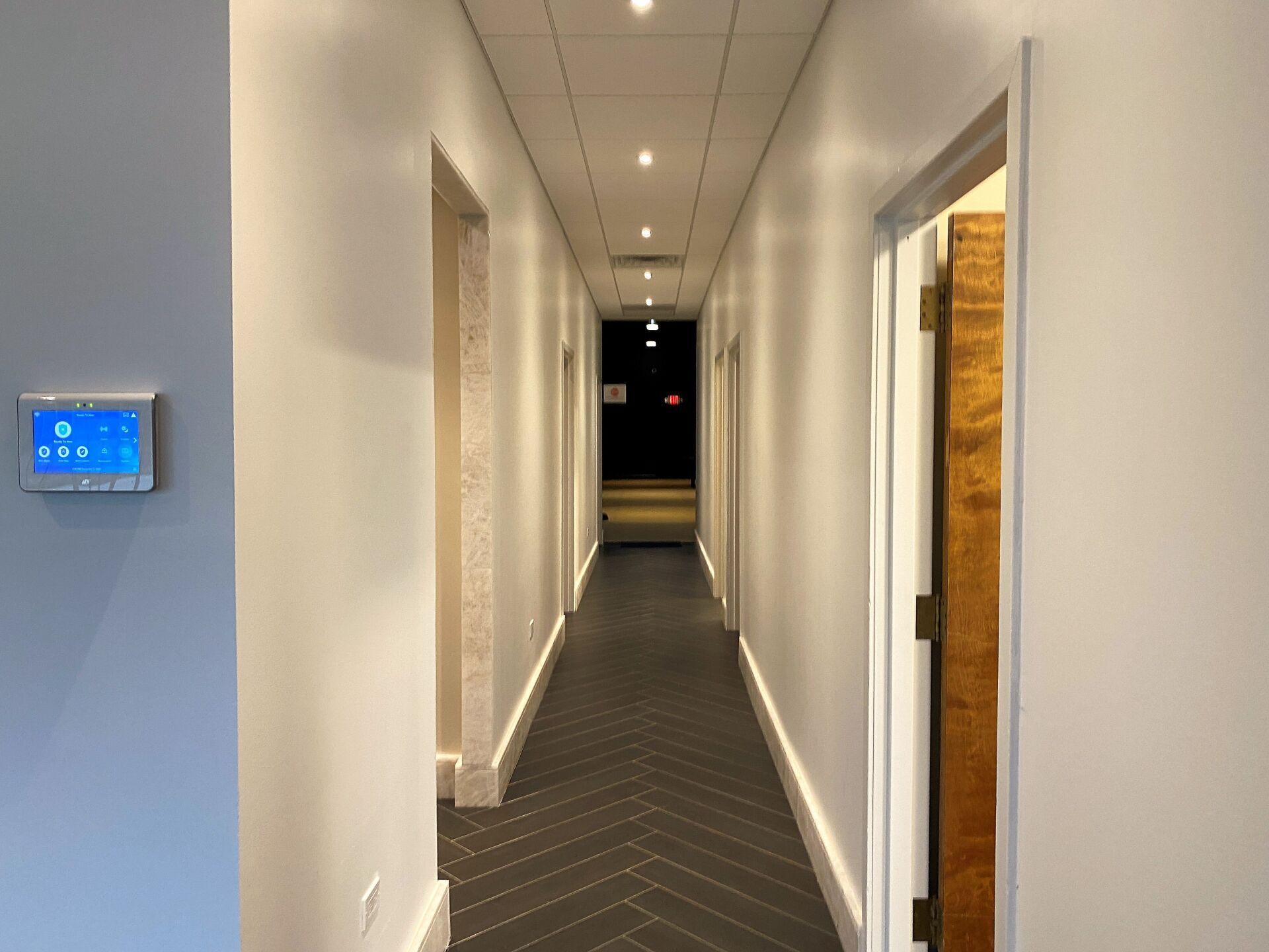 A long hallway with a thermostat on the wall