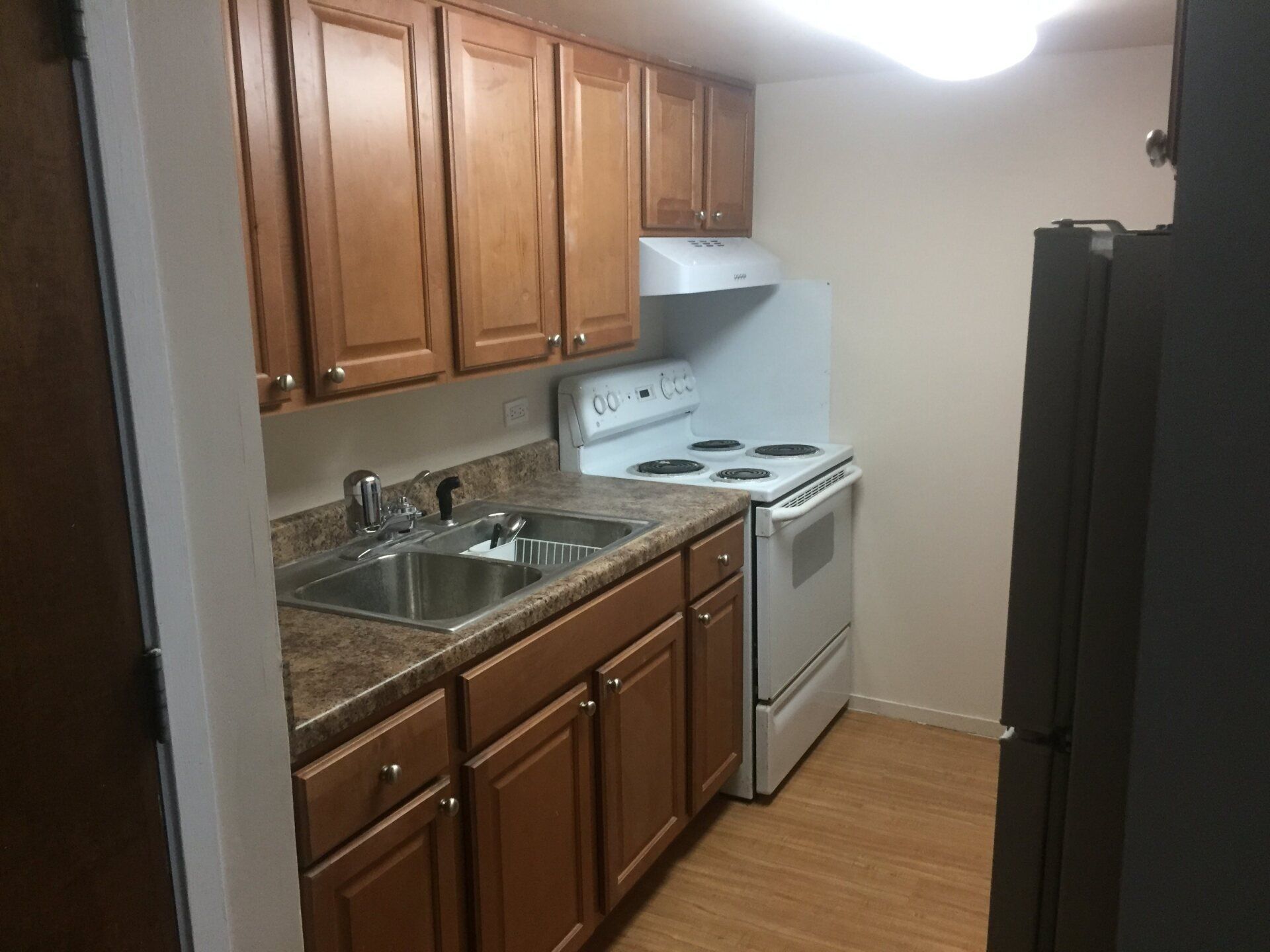 A kitchen with a stove , sink , and refrigerator