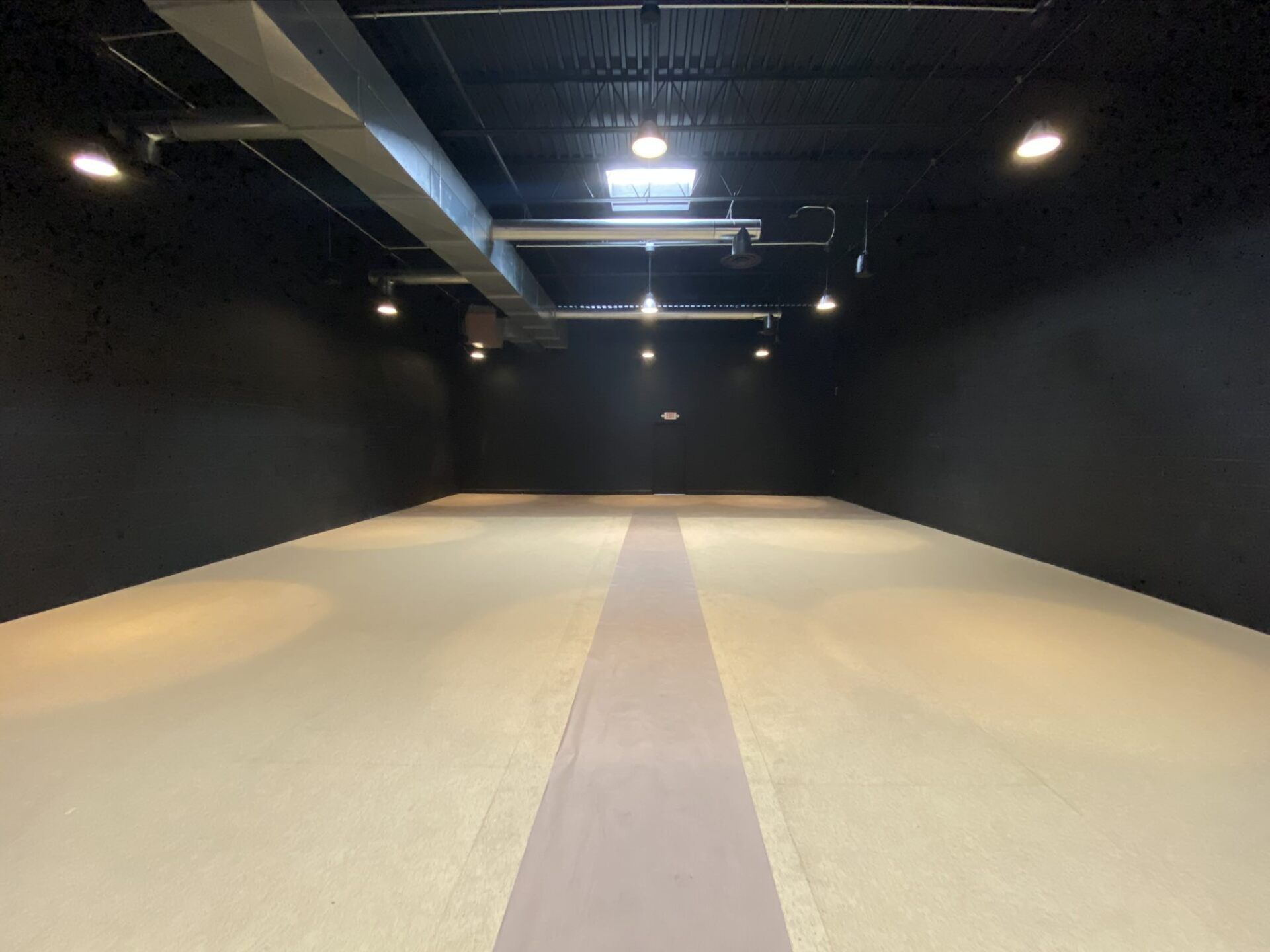 A large empty room with a white stripe on the floor