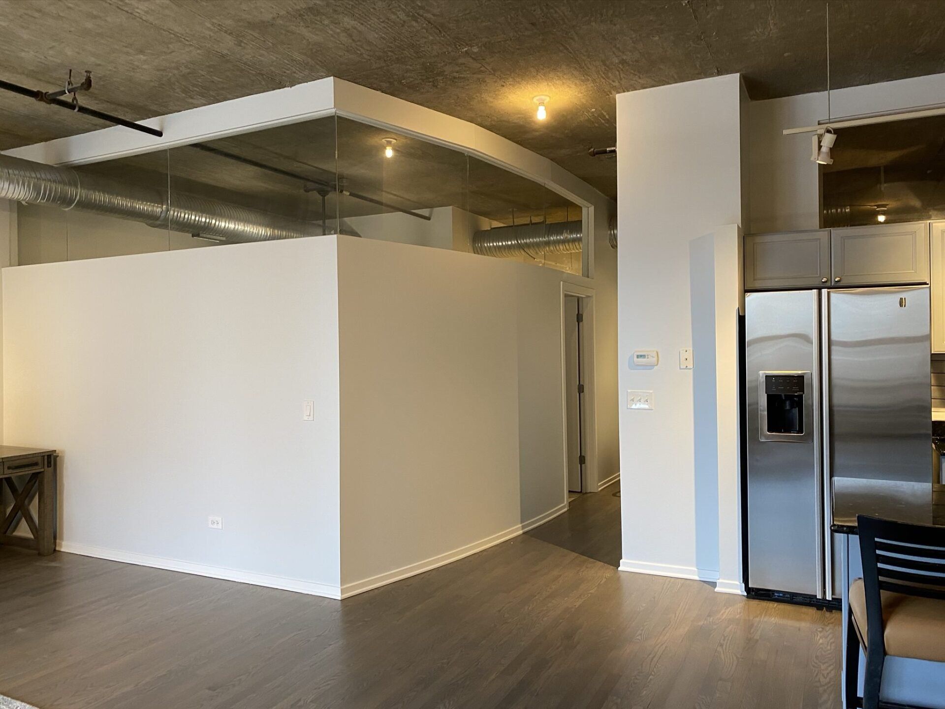 There is a stainless steel refrigerator in the middle of the room.