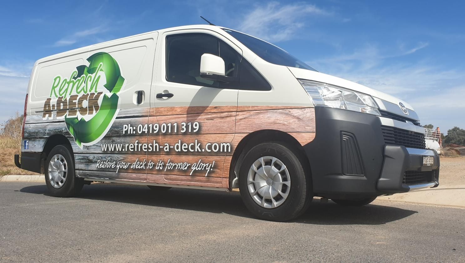 A White Van With a Wooden Wrap is Parked on the Side of the Road with Vehicle Wrap — Robinsons Sign Makers in Lavington, NSW
