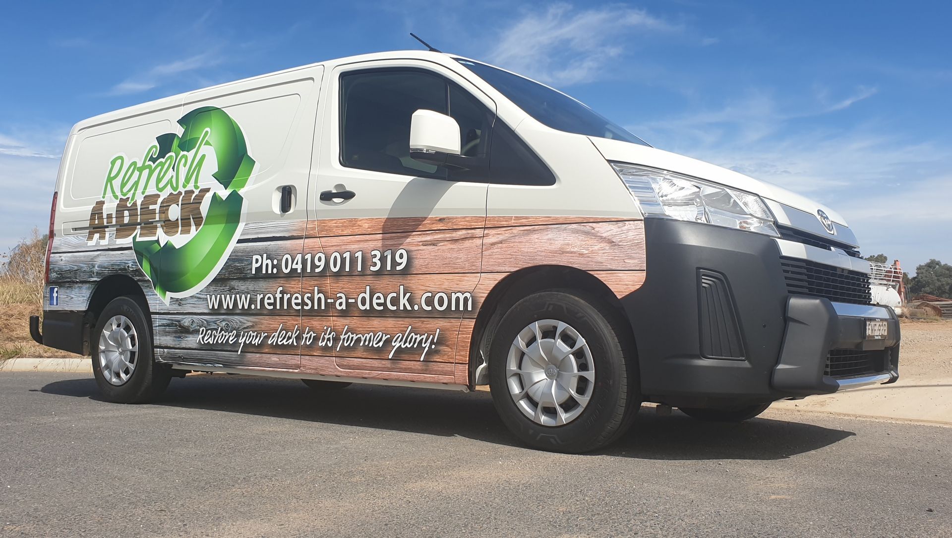 A White Van With a Wooden Wrap is Parked on the Side of the Road — Robinsons Sign Makers in Lavington, NSW