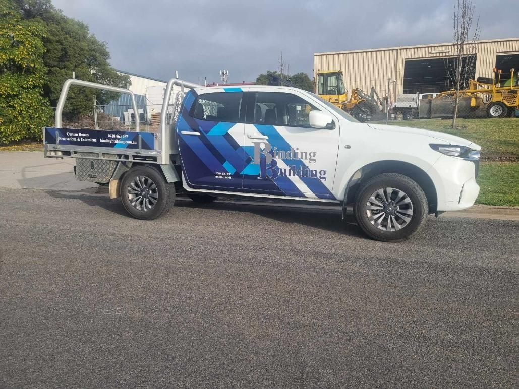 A White Bus is Parked on the Side of the Road with Vehicle Wrap — Robinsons Sign Makers in Lavington, NSW