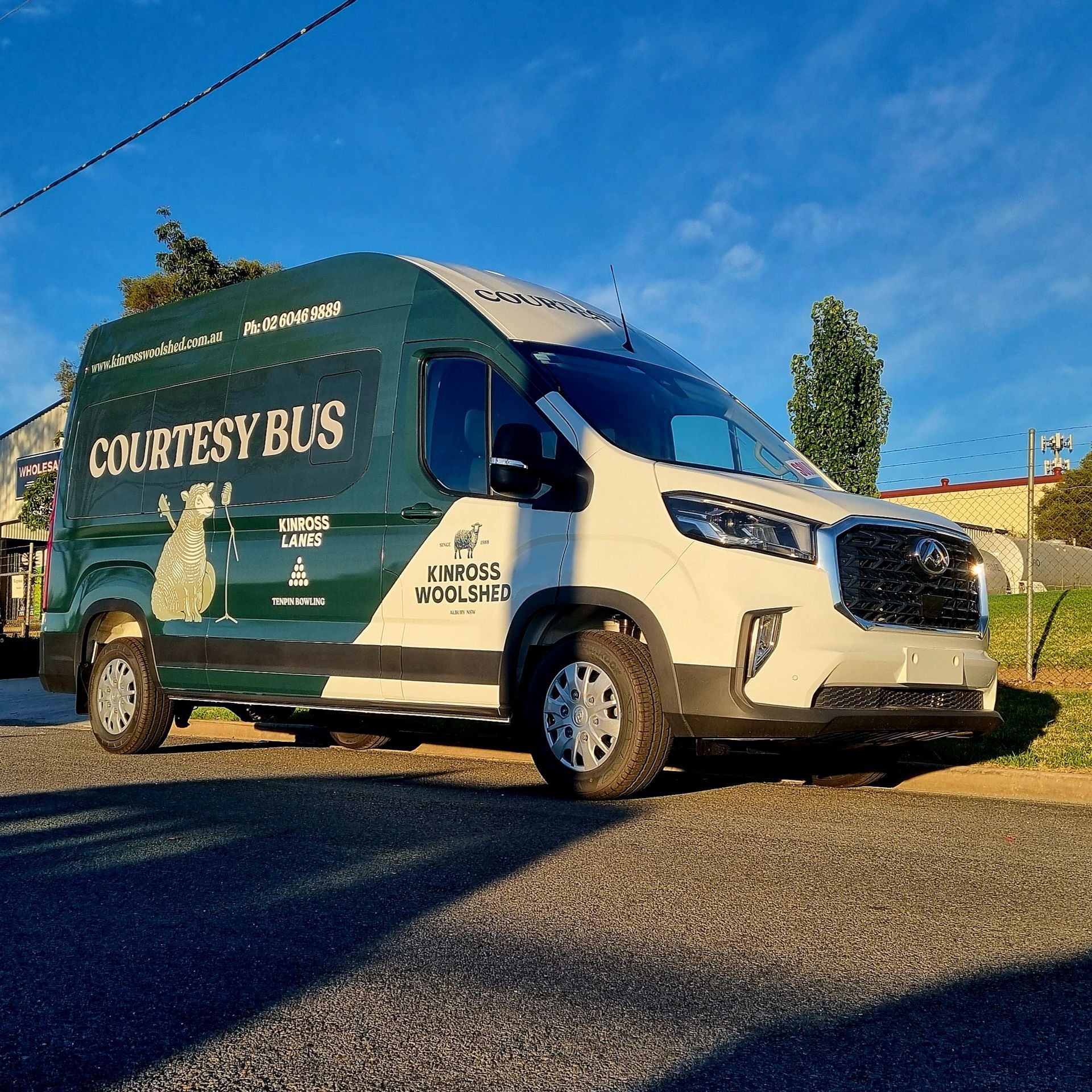 A Courtesy Bus is Parked on the Side of the Road — Robinsons Sign Makers in Lavington, NSW