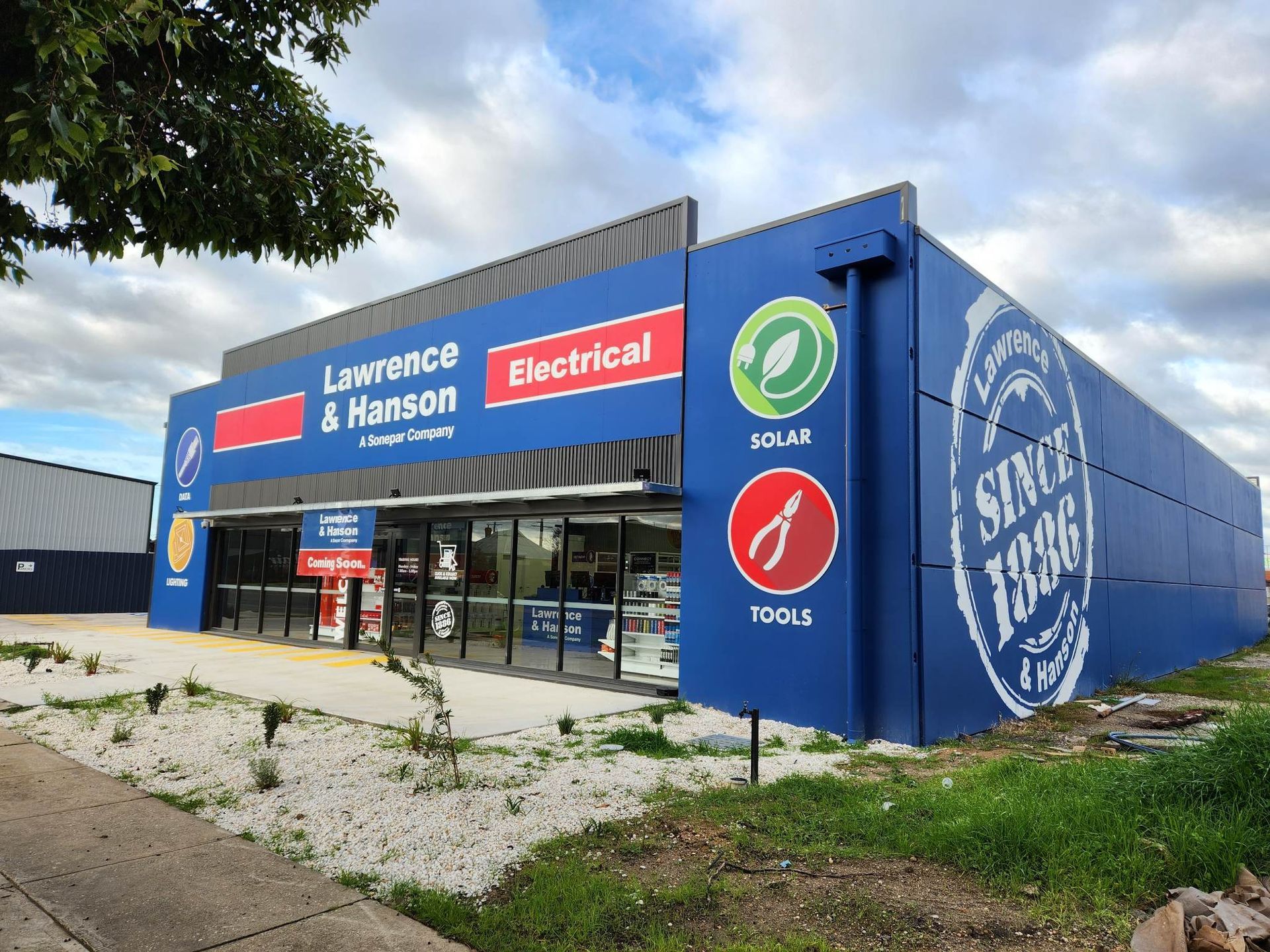 A large blue building with a sign that says lawrence & harrison electrical