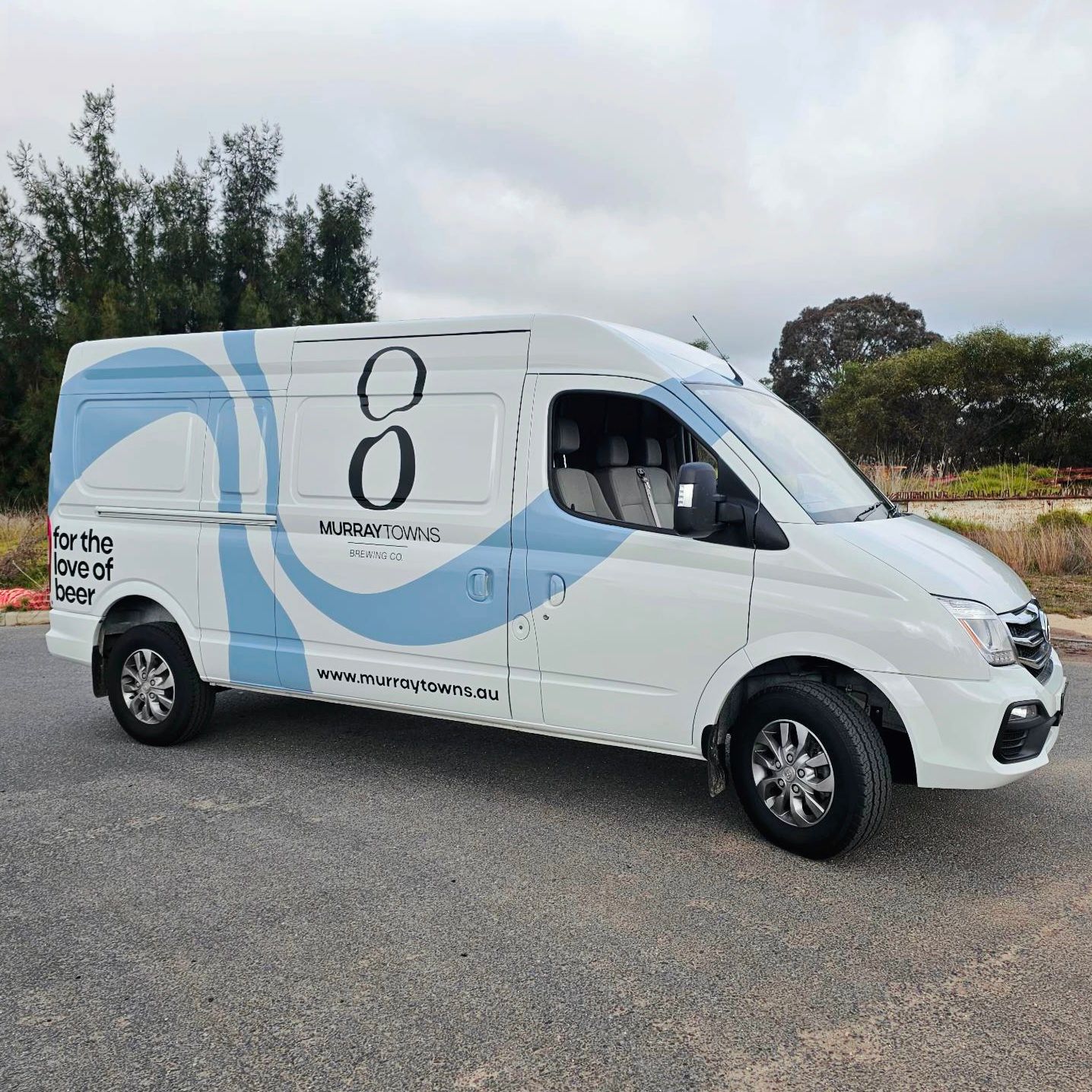 A wHite and Blue Van is Parked on the Side of the Road — Robinsons Sign Makers in Lavington, NSW