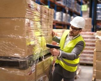 A man is scanning boxes in a warehouse.