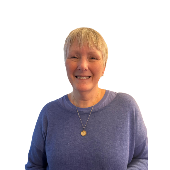 A woman wearing a purple sweater and a gold necklace smiles for the camera