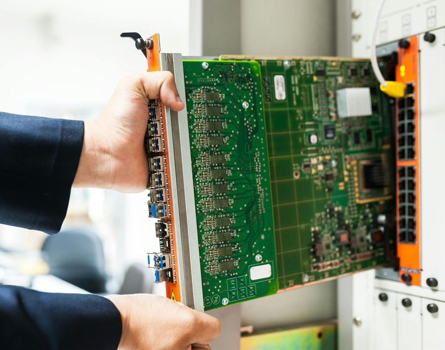 A person is holding a motherboard in their hands.