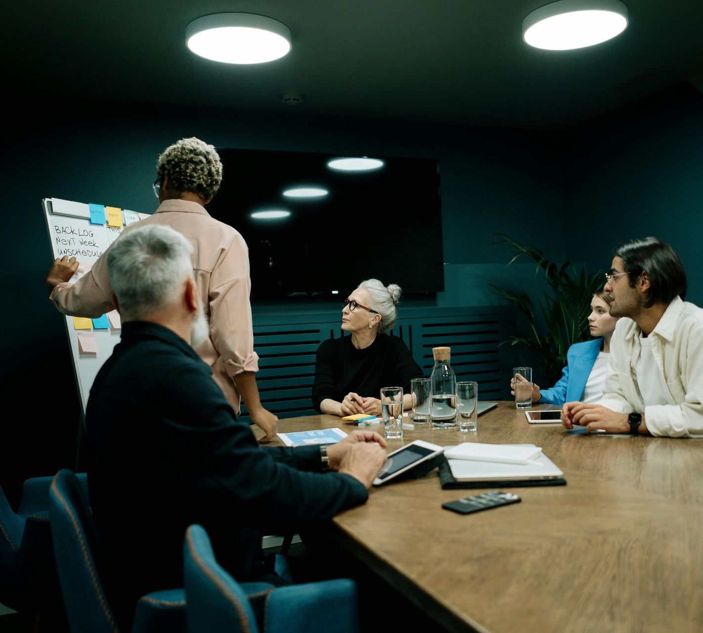 A group of people are sitting around a table in a conference room.