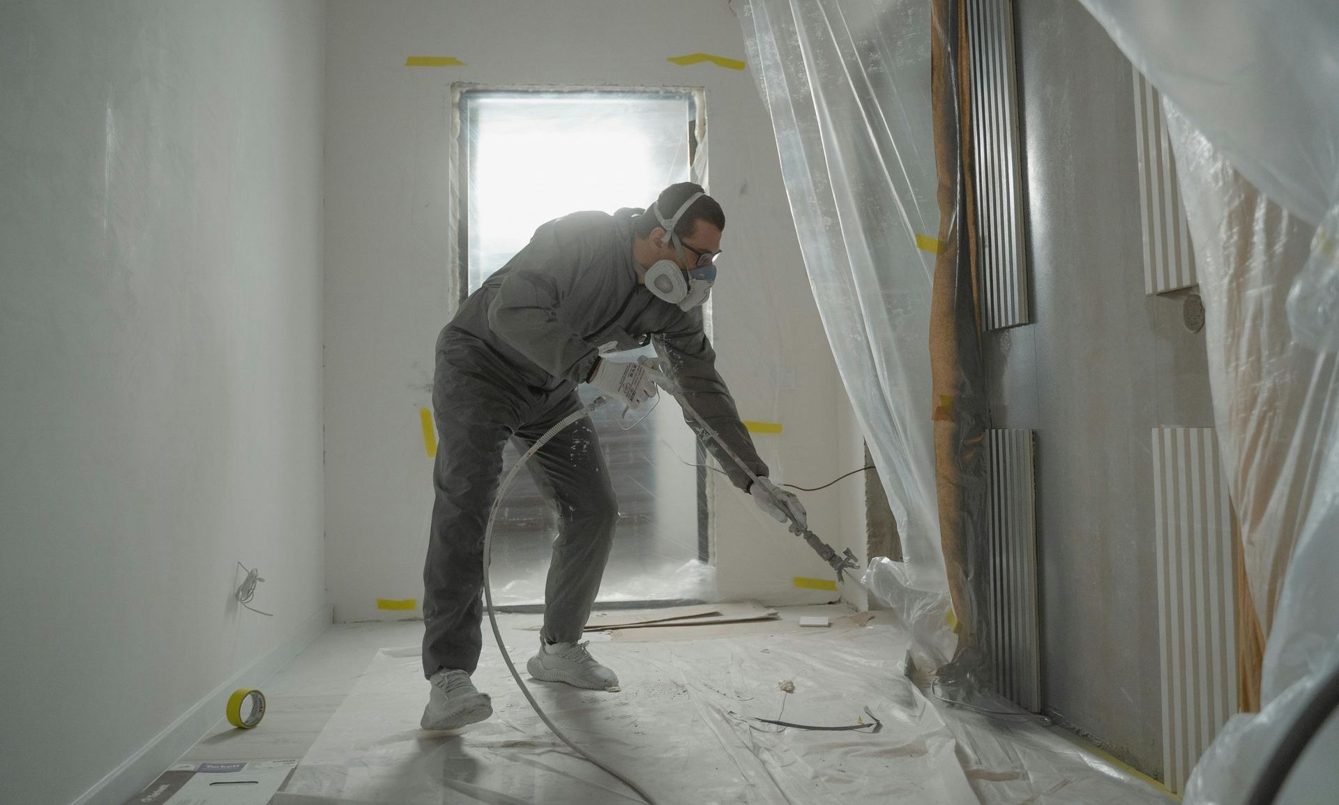 A man is using a vacuum cleaner to clean the floor of a room.