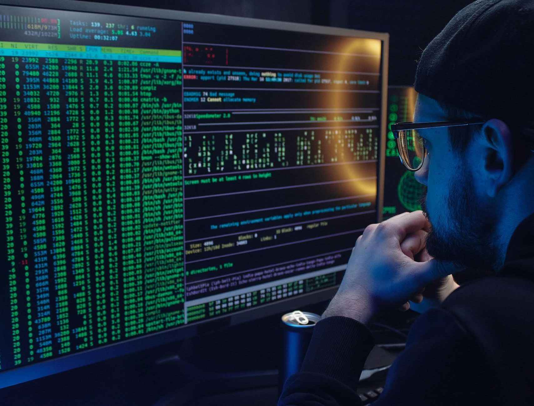 A man wearing glasses is looking at a computer screen.