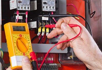 Electrician holding an Electronic Meter Device — Reef Electrical in Cannonvale, QLD