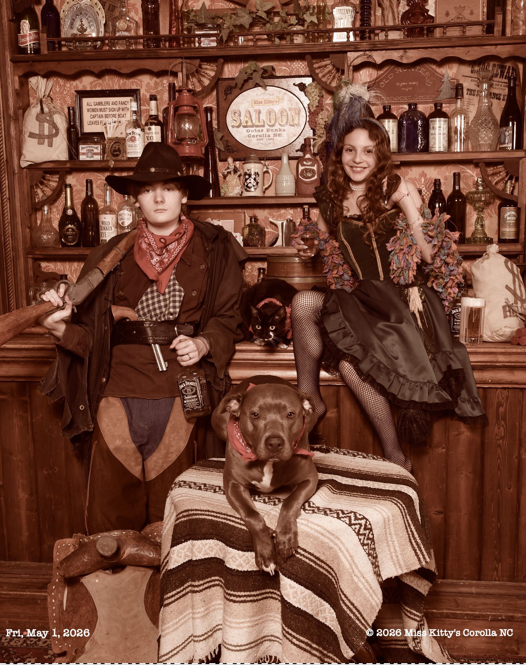 Sepia-toned western saloon scene with two young adults with a dog and a cat. Old Time Pet Photo with a dog in a hat and a cat, Miss Kitty's Old Time Photos and Gifts