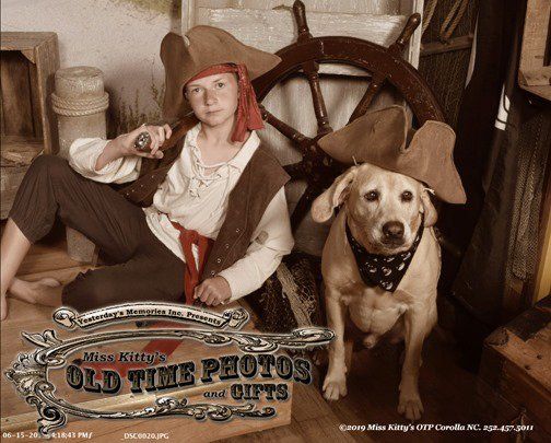 a young boy dressed as a pirate is sitting next to a dog
