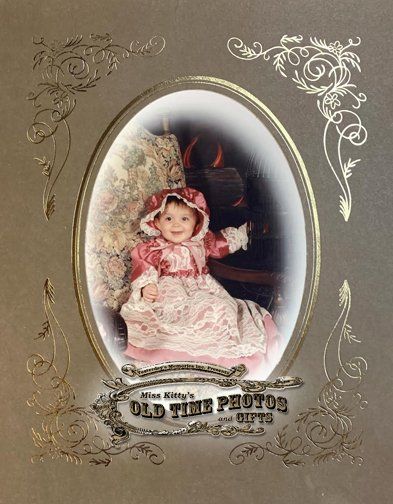 an old time photo of a baby in a pink dress