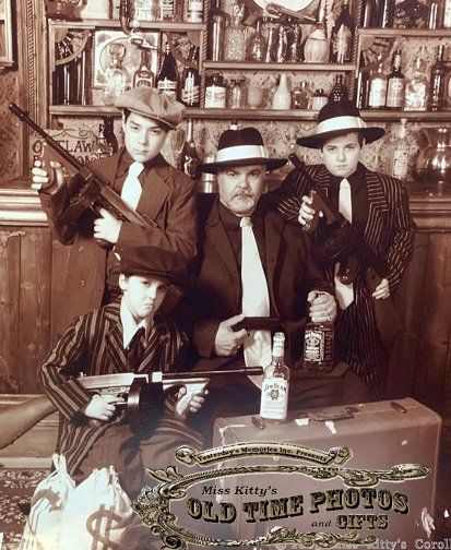 a day and his three sons dressed as 1920 gangsters with Tommy guns  for and old time photo