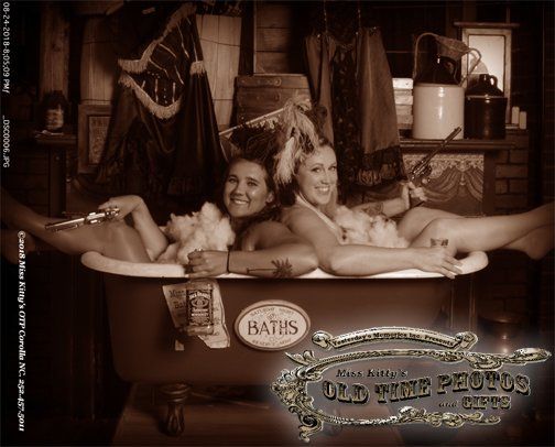 two women are laying in a bathtub that says baths