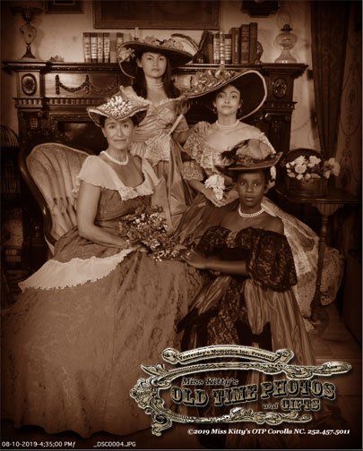 a sepia photo of four women dressed in old fashioned dresses