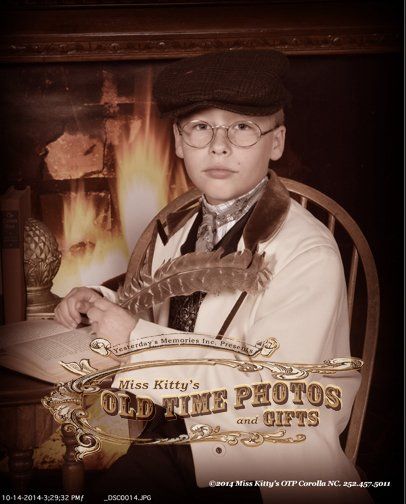 a boy is sitting in front of a fireplace in an old time photo - Miss Old Time Photos and Gifts    Corolla Outer Banks NC