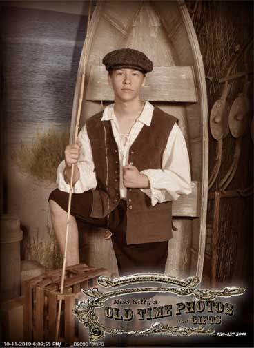 a young man is sitting in a boat holding a fishing rod - Miss Kitty's Old Time Photos and Gifts    Corolla Outer Banks NC
