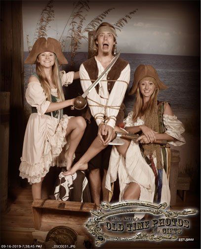 a man and two women dressed as pirates pose for a photo