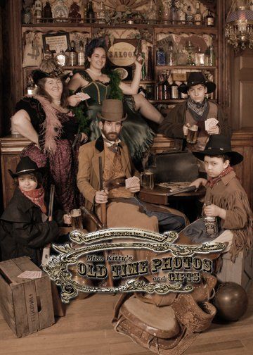 a group of people dressed in cowboy costumes are posing for a picture in a saloon .