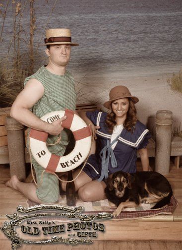 a man. a  woman and a dog posing for Old Time picture with a life preserver that says to beach