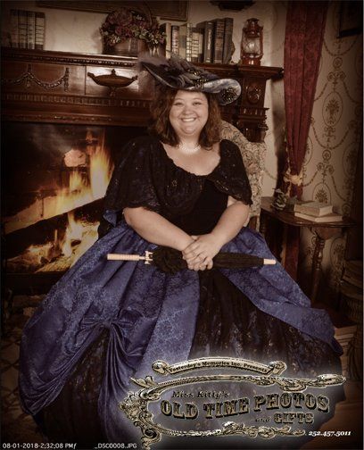 a women in a fancy dress posing for a old time photo on the outer banks