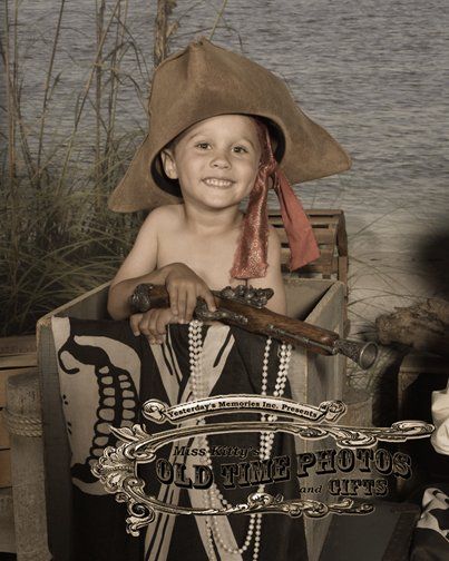 young boy dressed as a pirate with a treasure chest in the background - Old Time Photos and Gifts    Corolla Outer Banks NC