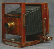 an old wooden camera is sitting on a table .