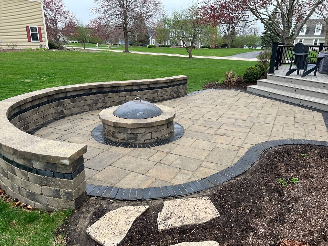 Picture of an outdoor area with a firepit made with paver stones. 