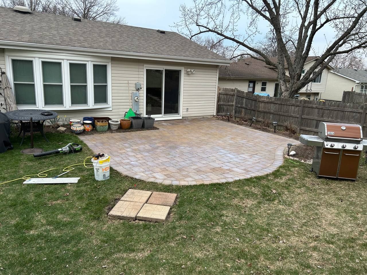 Before picture of an outdoor paver patio. You can tell that some pavers are uneven. 