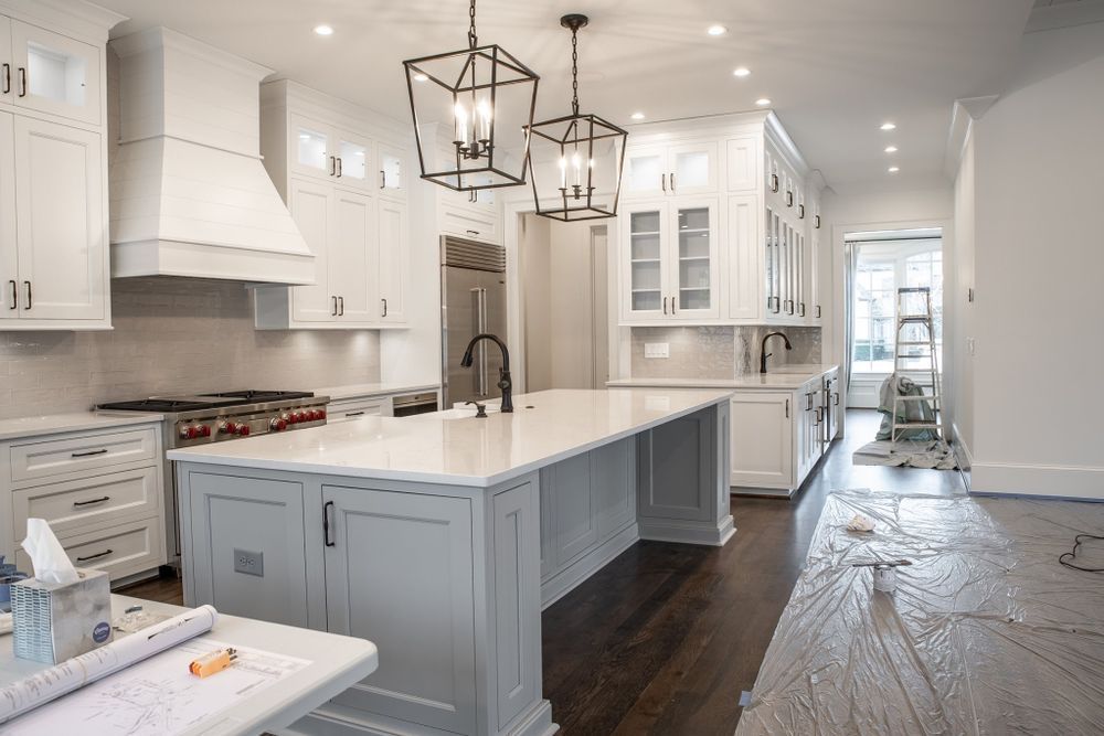 A kitchen under construction with white cabinets and a large island.