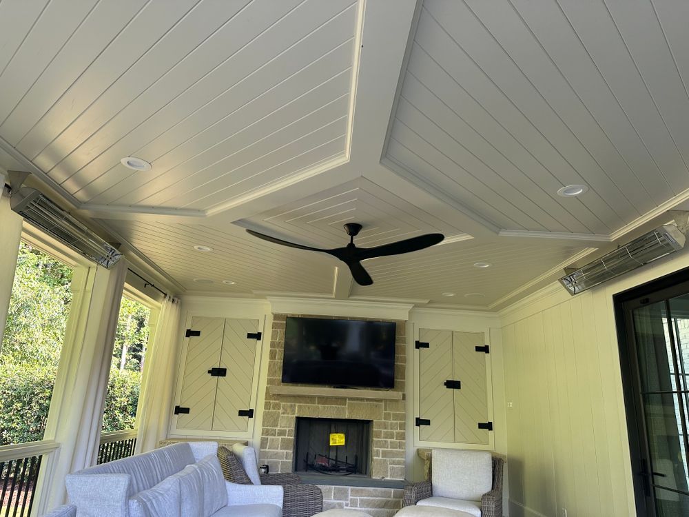 A living room with a fireplace and a ceiling fan.