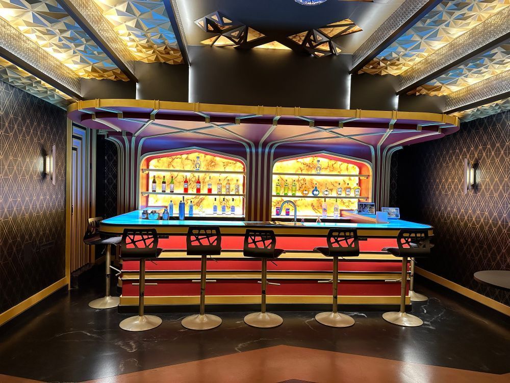 A bar with stools and a blue table in a room.