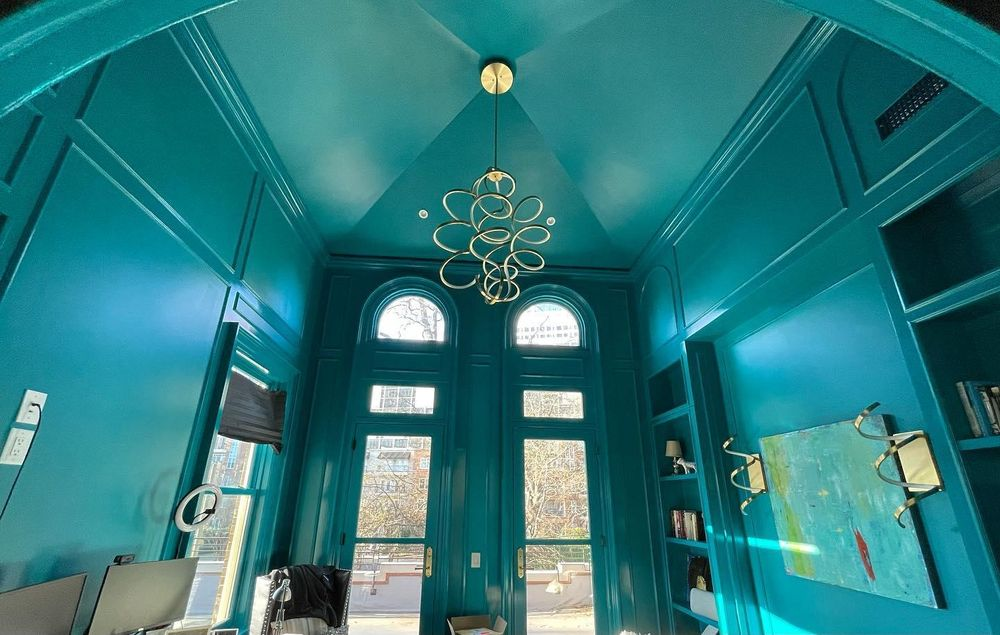 A room with blue walls and a chandelier hanging from the ceiling.