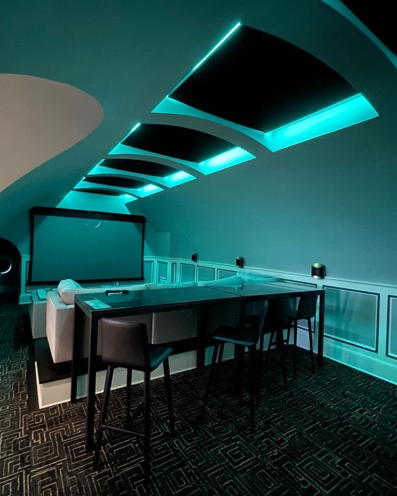 A dark room with a projector screen and a bar