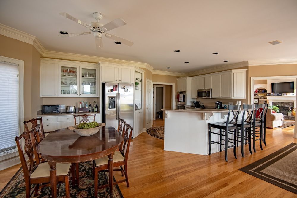 A kitchen with a table and chairs and a ceiling fan.