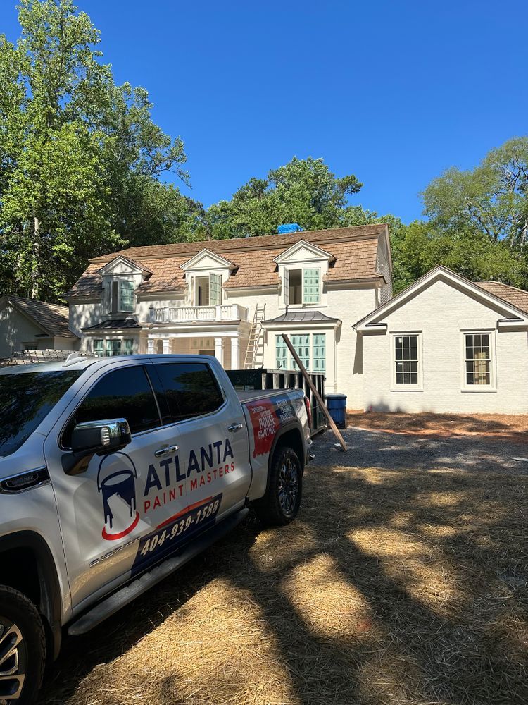 A white truck is parked in front of a white house.
