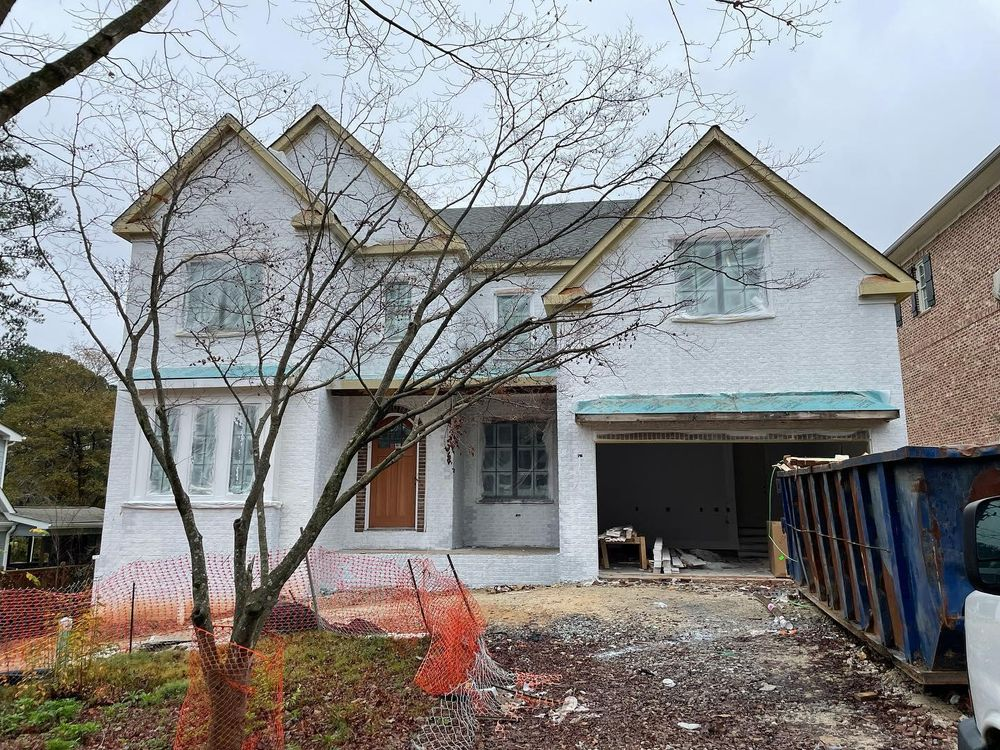 A large white house is being built in a residential area.