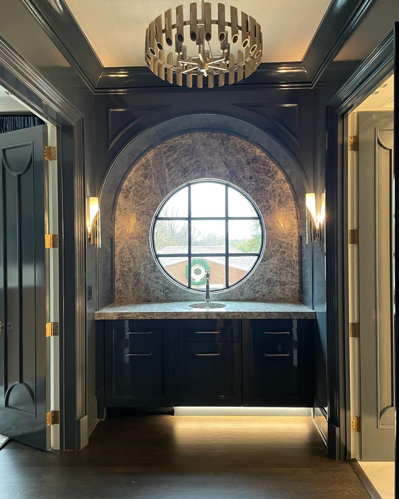 A kitchen with a round window and a chandelier hanging from the ceiling.