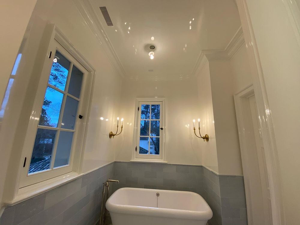 A bathroom with a bathtub and a window.