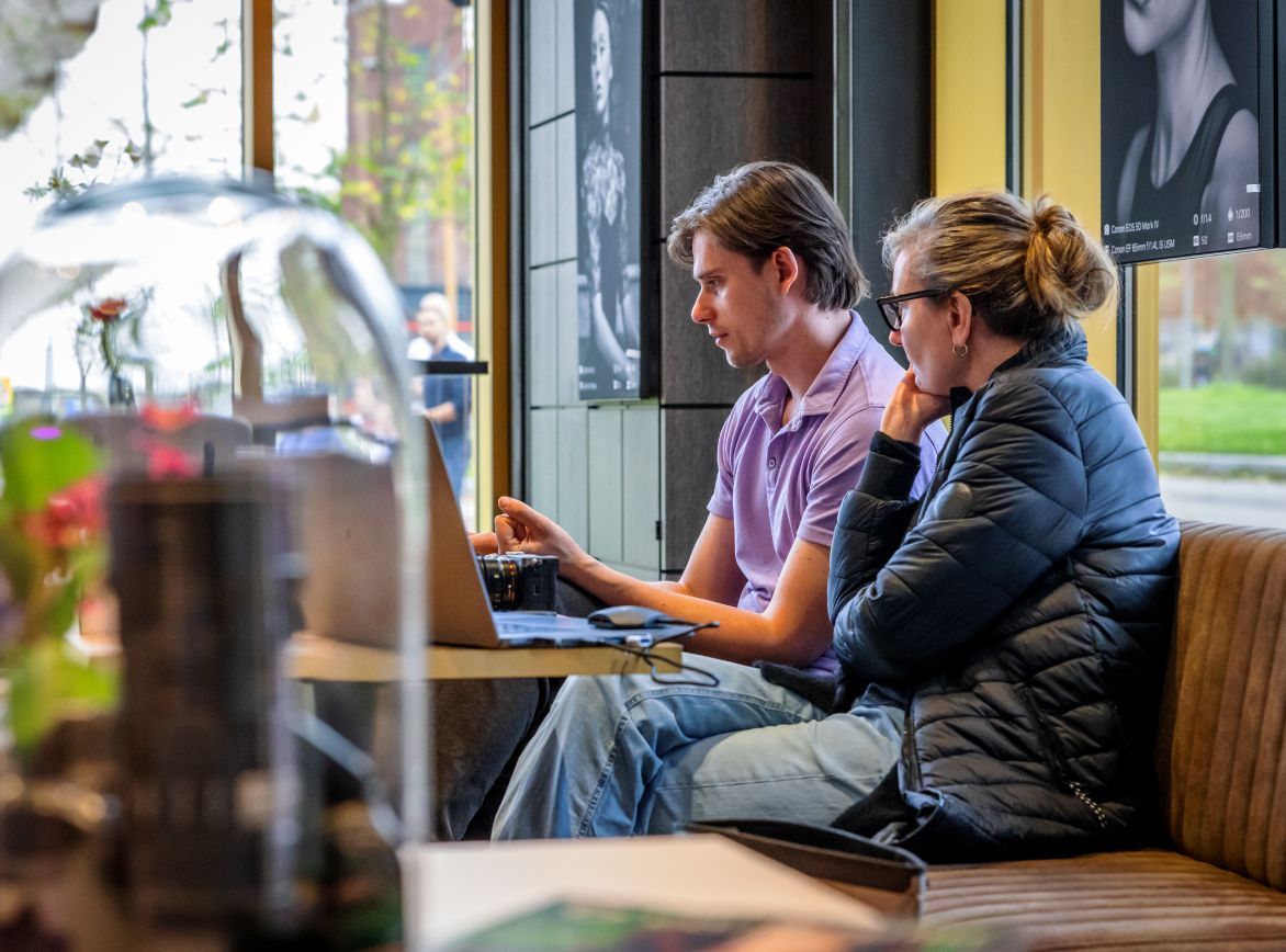 A woman walking in a room with a sign that says ' brave ' on it