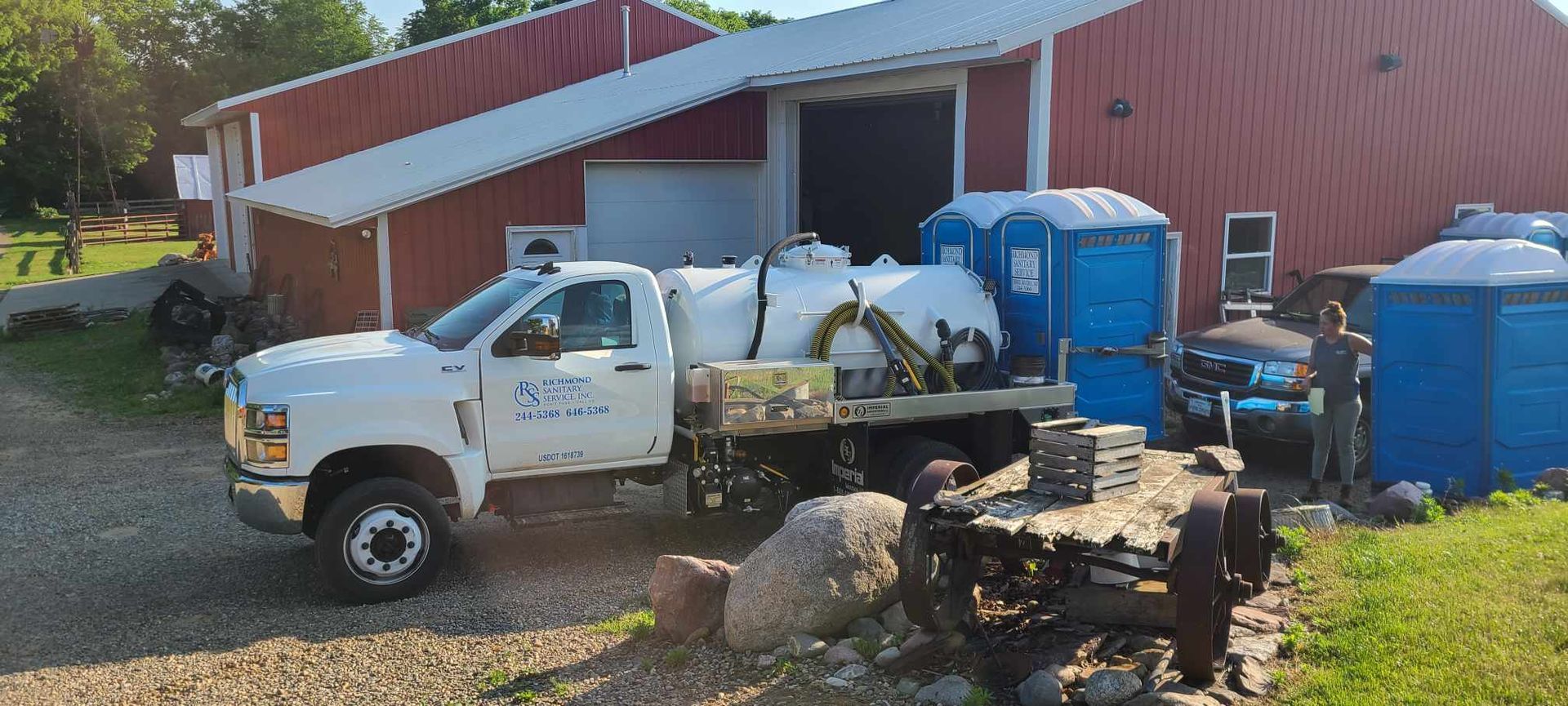 White Truck is Parked in Front of a Red Barn — Marcellus, MI — Richmond Sanitary Service Inc