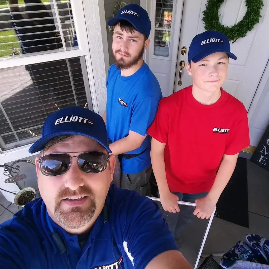 A man and two women are standing next to each other holding cleaning supplies.