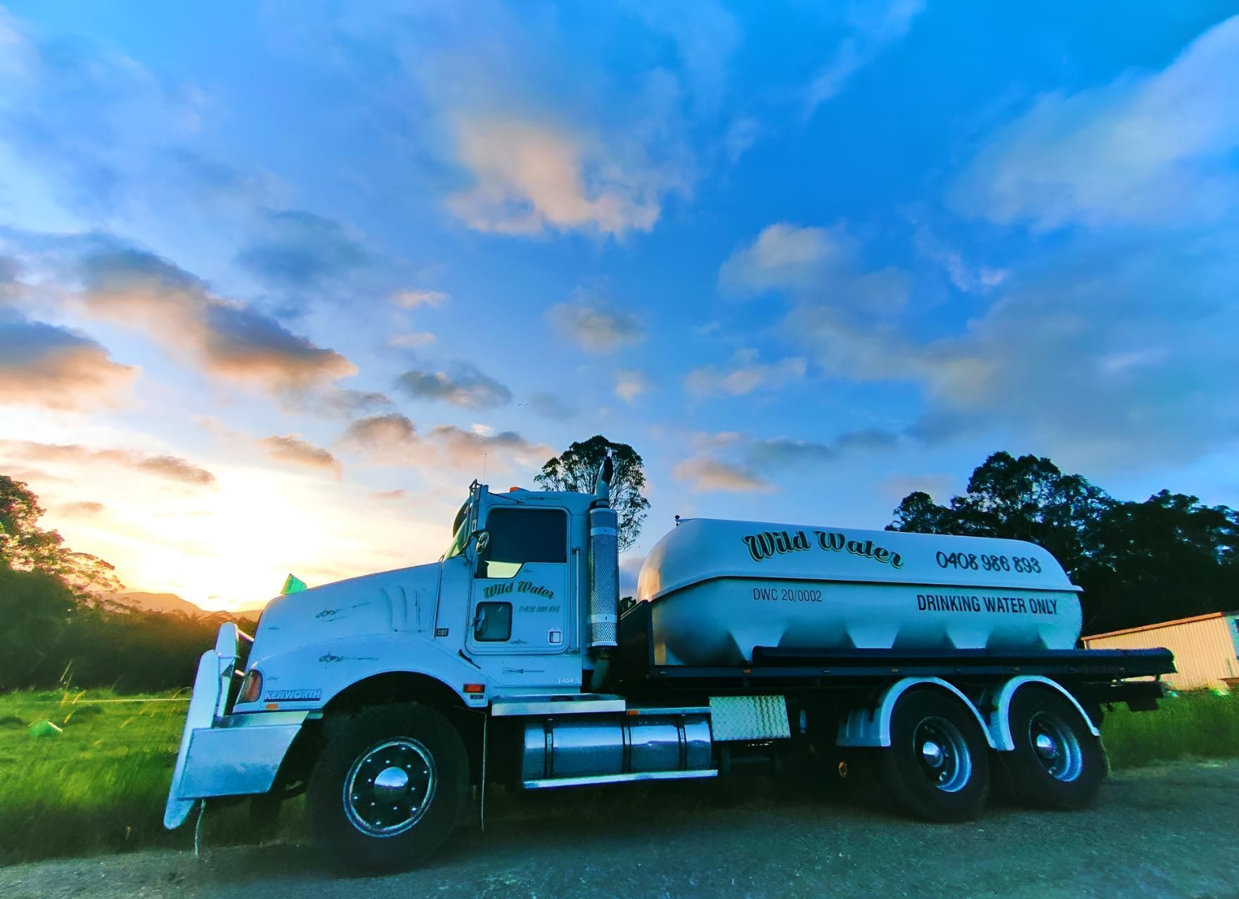 A Large White Truck is Parked on the Side of the Road at Sunset — Wild Water Delivery in Peachester, QLD